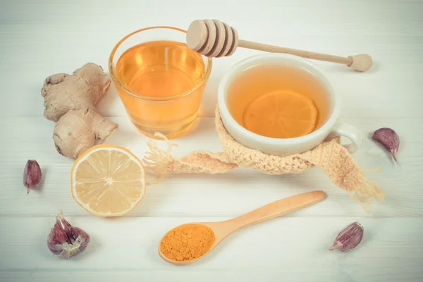 Винтажное фото, чашка чая с лимоном и ингредиенты для приготовления согревающего напитка — стоковое фото