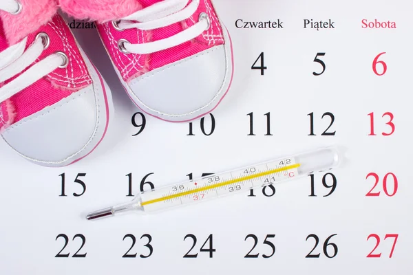 Termometro e scarpe per neonato in calendario, in attesa per il bambino — Foto Stock