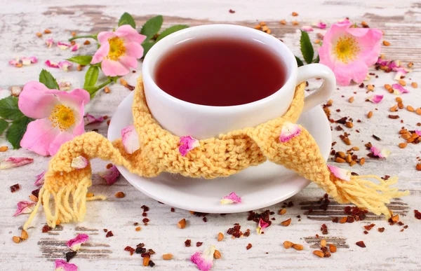 Kopje thee met wild rose bloem op oude rustieke houten achtergrond — Stockfoto