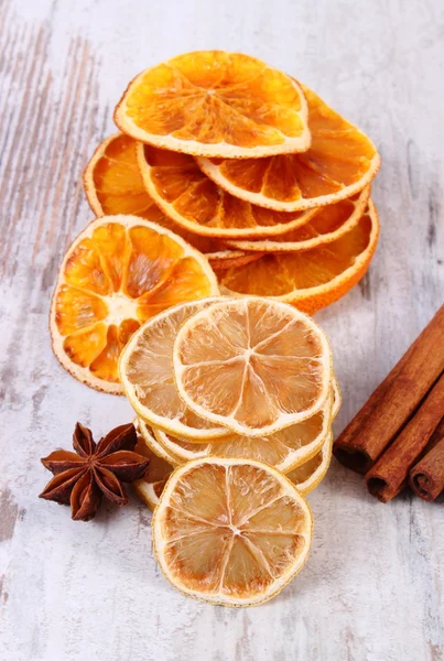 Кусочки сушеного лимона, апельсина и специй на старом деревянном фоне — стоковое фото