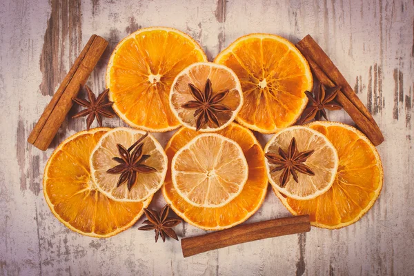 Vintage foto, plakjes van uitgedroogde citroen, sinaasappel en kruiden op oude houten achtergrond — Stockfoto