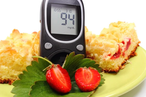 Glucosímetro y trozos de torta de levadura con fresas — Foto de Stock