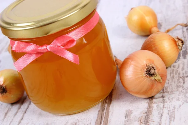 Φρέσκο βιολογικό μέλι σε γυάλινο βάζο και κρεμμύδια σε ξύλινο υπόβαθρο, την υγιεινή διατροφή και την ενίσχυση της ασυλίας — Φωτογραφία Αρχείου