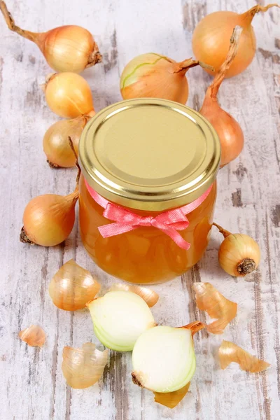 在玻璃罐和洋葱的木制背景、 健康营养和增强免疫力的新鲜有机蜂蜜 — 图库照片