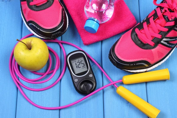 Glucomètre, chaussures de sport, pomme fraîche et accessoires de fitness sur les planches bleues — Photo