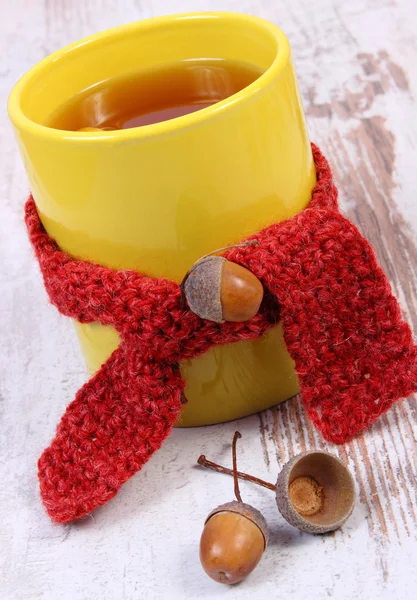 Taza de té caliente con limón envuelto lana bufanda, calentamiento de la bebida para la gripe, decoración de otoño — Foto de Stock