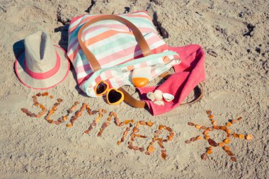 Yazın, kehribar taşı ve aksesuarlardan oluşan güneş şeklinde bir yazı. Rahatlamak için ya da kumsalda güneşlenmek için. Seyahat ve tatil zamanı kavramı
