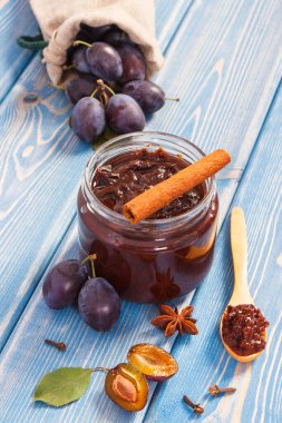Taze erik reçeli, ahşap tahtalarda meyve ve baharatlar, sağlıklı tatlı konsepti.