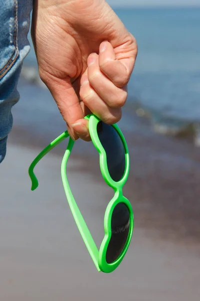 海滩上戴着心形太阳镜的女人的手 夏季和假期 — 图库照片