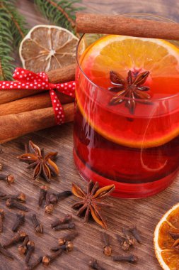 Noel için sıcak şarap ya da kış akşamı ahşap yüzey tahtasında, ladin dalları ve baharatlar, tarçın anason karanfilleri kurutulmuş ve taze portakal.