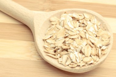 Tahta kaşıkla yulaf ezmesi. Beslenme lifleri ve doğal mineraller olarak sağlıklı malzemeler