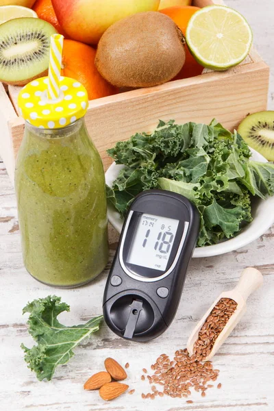 Glucometer with result of sugar level and healthy smoothie from fruits and vegetables. Diabetes, slimming and nutritious dessert concept