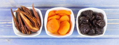 Kurumuş meyveler, kayısı armudu ahşap tahtalar üzerinde beyaz cam kase, sağlıklı beslenme