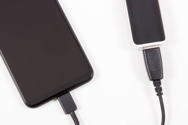 Elektrik prizi bağlı akıllı bir telefon. Telefon şarj oluyor. Beyaz arkaplan