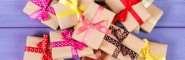 情人节 生日或其他喜庆活动用五彩缤纷的缎带包裹着的礼物躺在紫色的木板上 — 图库照片