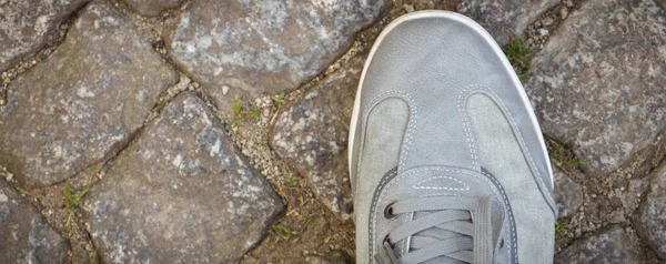 石子或石子制成的人行路上穿的舒适的灰色皮鞋 文本或登记的复制空间 — 图库照片