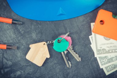 Ev şekilli anahtarlar, para birimleri dolar ve mühendislik işleri için iş aletleri. Ev yapma ya da satın alma konsepti. Teknoloji