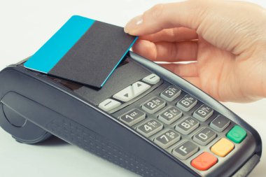 Kadının eli erişimi olmayan kredi kartıyla ödeme terminalini kullanıyor. Nakitsiz ödemeler için.
