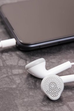 Siyah cep telefonu, kulaklıklı akıllı telefon. Elektronik ekipman kullanılıyor