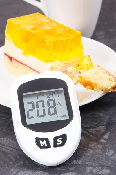 Glucometer with high result of measuring sugar level and creamy fruit cake with jelly. Nutrition during diabetes. Delicious dessert for different occasions