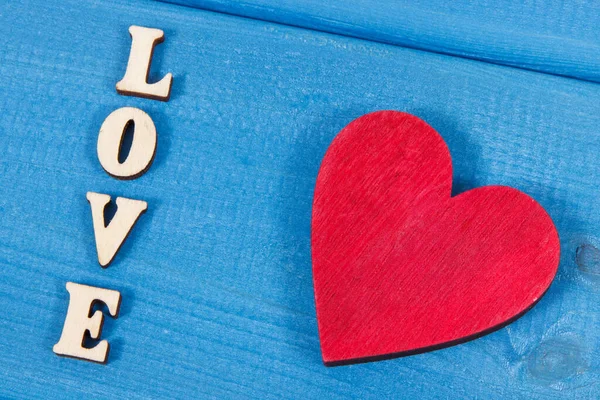 红木心形 蓝色板上写着爱 作为情人节的象征 — 图库照片