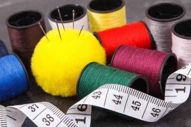 Renkli iplik makaraları, iğne ve mezura. Dikiş ve dikiş için aksesuarlar