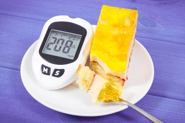 Glucometer with high result of measuring sugar level and creamy fruit cake with jelly. Nutrition during diabetes. Delicious dessert for different occasions