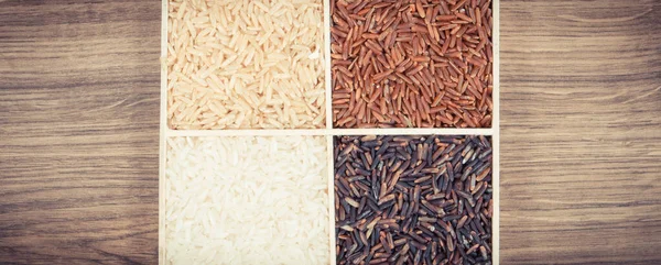 Vintage photo, White, brown, black and red rice on rustic board, concept of healthy, gluten free food and nutrition