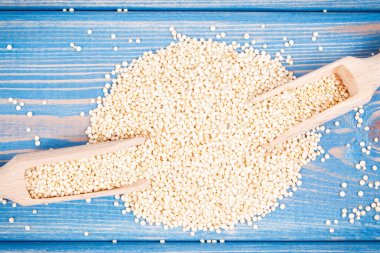 Doğal mineraller ve vitaminler içeren ahşap kaşıklarla dolu kinoa tohumları, sağlıklı beslenme kavramı.