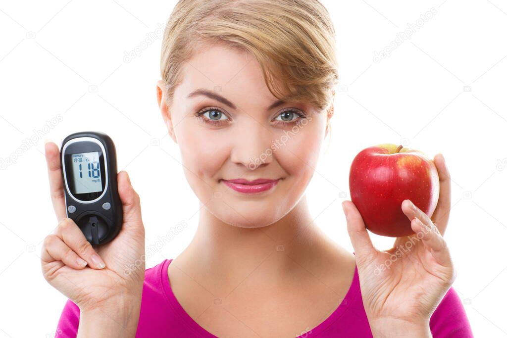 Happy woman holding glucose meter with positive result of measurement sugar level and fresh ripe apple, concept of diabetes, checking sugar level, white background