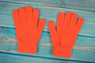 Mavi tahtalardaki pamuk ya da yünden yapılmış kadınlar için kırmızı eldivenler, sonbahar ya da kış konsepti için kalın elbiseler