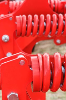 Çelikten yapılmış sert kırmızı yay. Büyük endüstriyel ya da tarımsal makinenin bir parçası. Teknoloji