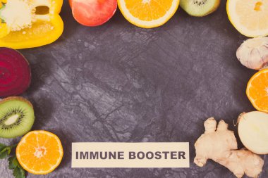 Yazılı bağışıklık güçlendirici ve içinde doğal vitaminler bulunan sebzeli taze olgun meyveler. Covid-19 zamanlarında bağışıklık güçlendirici. Yazı için yer