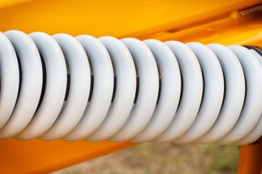 Çelikten yapılmış sert gri yay. Endüstriyel ya da tarımsal makinenin bir parçası. Teknoloji