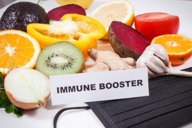 Yazılı bağışıklık güçlendirici, taze olgun sağlıklı meyve ve sebzeler içinde doğal vitaminler ve koruyucu maske var. Covid-19 zamanlarında bağışıklık güçlendirici