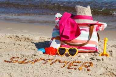 Yazlık kehribar taşlarından yapılmış, gevşemek için aksesuarlar güneşlenmek için ve kumsalda oynamak için çocuklar için oyuncaklar. Seyahat, turizm ve tatil zamanı kavramı