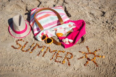 Yazın, kehribar taşı ve aksesuarlardan oluşan güneş şeklinde bir yazı. Rahatlamak için ya da kumsalda güneşlenmek için. Seyahat ve tatil zamanı kavramı