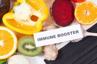 Yazılı bağışıklık güçlendirici, taze olgun sağlıklı meyve ve sebzeler içinde doğal vitaminler ve koruyucu maske var. Covid-19 zamanlarında bağışıklık güçlendirici