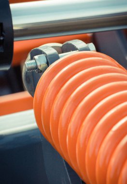 Büyük ve sert turuncu çelik yay endüstriyel ya da tarımsal makinenin bir parçası olarak. Teknoloji