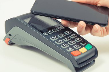 Kredi kartı okuyucu ve cep telefonunu nakit ödemelerde kullanıyor. Ödeme terminali. Finans ve bankacılık kavramı