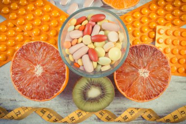 Vitamin, mezura ve ilaç içeren taze doğal meyveler. Sağlıklı beslenme ve takviyeler arasında seçim yapmak.