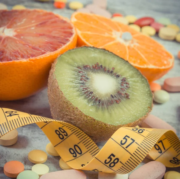 新鮮な自然果物 テープ測定と医療用薬 果物を食べることと免疫力を強化するためのサプリメントを取ることの間の痩身と選択 — ストック写真