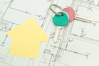 Kağıttan yapılmış ev şekli, ev anahtarları ve elektrik tesisatı ile planlanmış şemalar. Ev konsepti inşa etmek. Teknoloji
