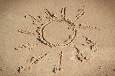 Kumsalda kumdaki güneşin şekli. Tatil zamanı kavramı