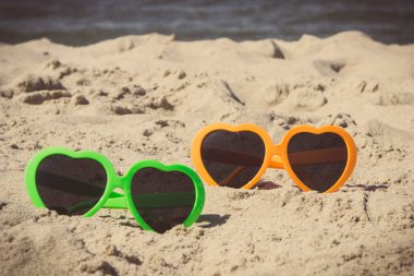 Kumsalda kumsalda güneşten korunmak için güneş gözlüğü. Seyahat ve tatil zamanı kavramı