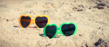 Kumsalda kumsalda güneşten korunmak için güneş gözlüğü. Seyahat ve tatil zamanı kavramı