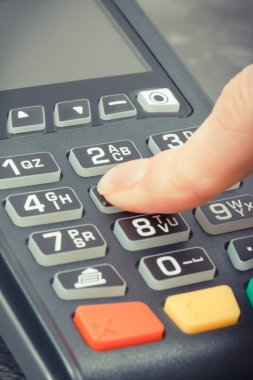 PIN kodunu girmek için kredi kartı okuyucu kullanan bir kadın. Nakitsiz ödeme. Finans ve bankacılık kavramı