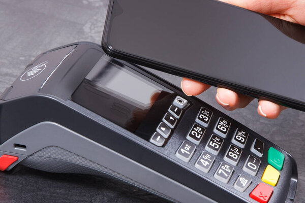 Мобильный телефон или смартфон с платежным терминалом. Читатель кредитных карт. Оплата покупок без наличных. Концепция финансов и банковского дела