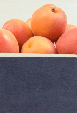 Kayısı ya da şeftali, ahşap kutuda sağlıklı atıştırmalık ya da tatlı olarak. Doğal vitaminler ve mineraller içeren yiyecekler. Yazı için yer