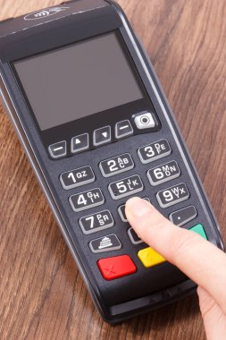 PIN kodunu ödeme terminaline giriş yapan bir kadın eli. Alışveriş için para ödemeden. Kredi kartı okuyucu. Finans kavramı